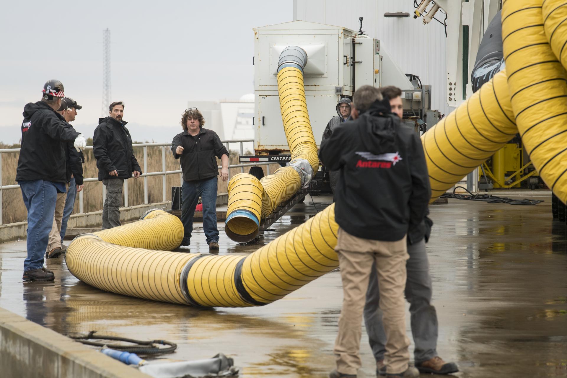An Antares rocket and its launch crew at Pad-0A at NASA's Wallops Flight Facility, the rocket on the ground before launch