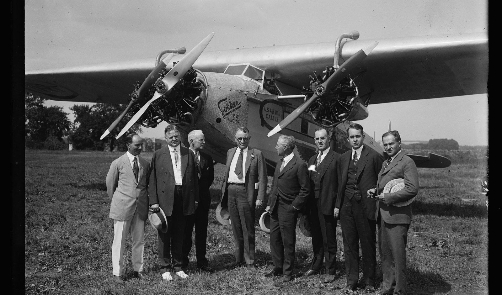 An early U.S. Air Mail trimotor with the people behind the contract mail routes posed in front of it